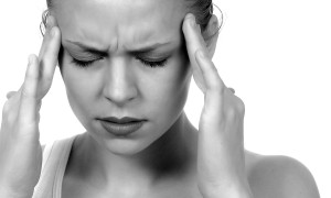woman rubbing temples to try and relieve pain from migraine