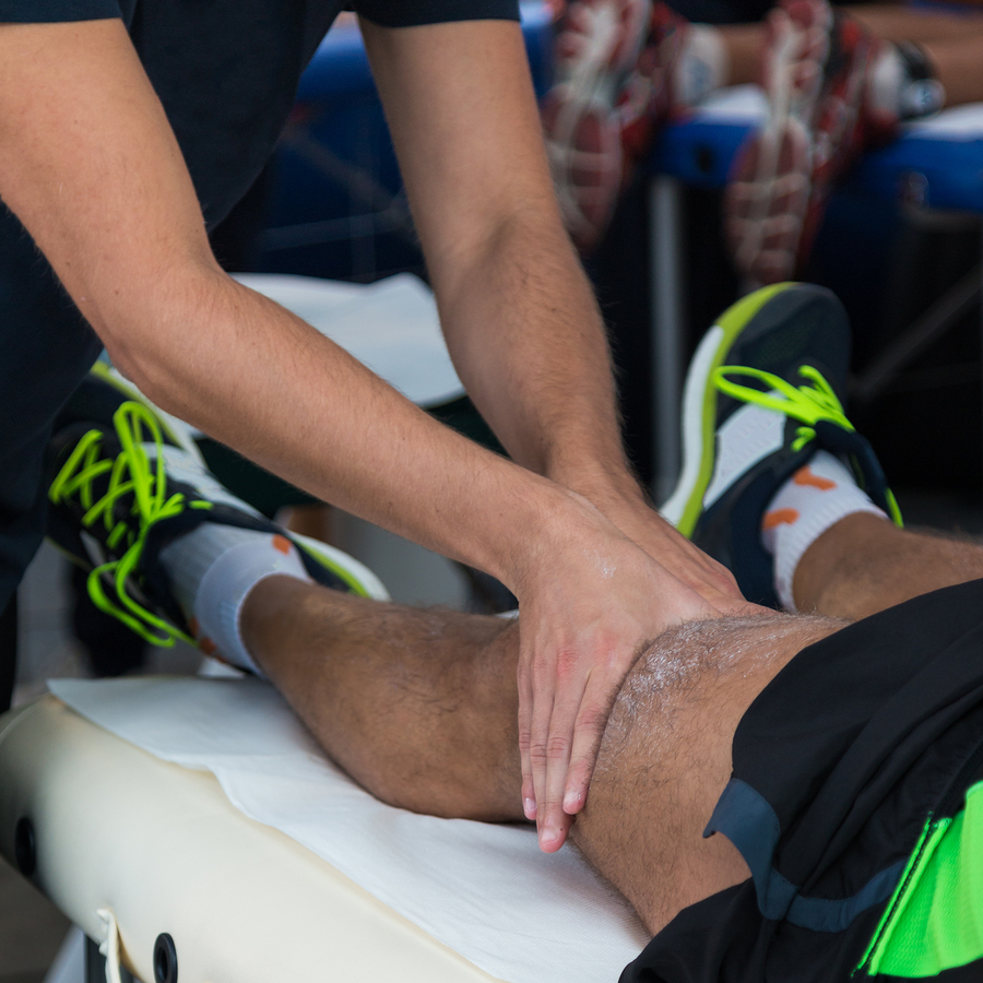 man getting a knee and thigh massage from a sports chiropractor